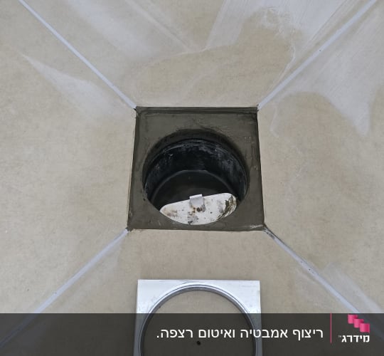 תמונה של חור ניקוז ברצפה עם מכסה מתכת